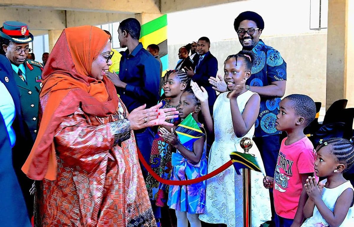 The President greeting a group of children holding Tanzanian flags at a public event